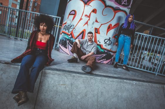 A group of young people sit in a skate park