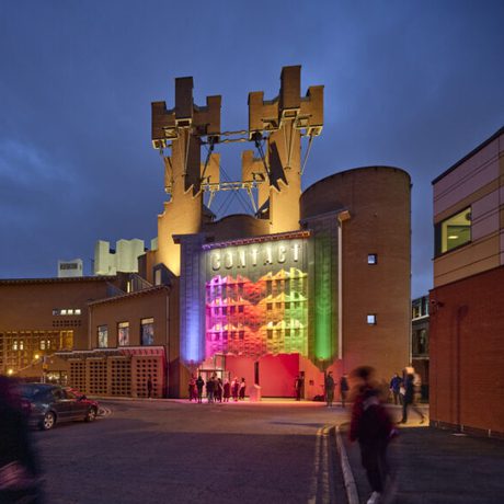 An image of the Contact building at dusk lit up in rainbow colours