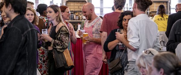 Contact bar full of people chatting with drinks in their hands