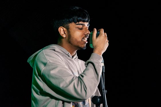 A young man sings into a microphone