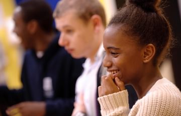 A young girl laughs during a workshop