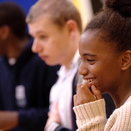 A young girl laughs during a workshop