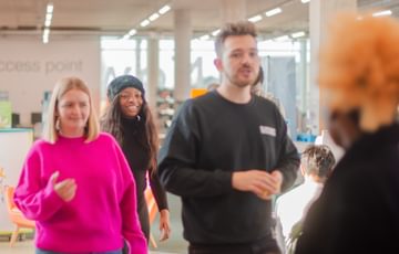Agency facilitators Amy and Josh walk purposefully through a library