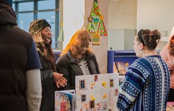 A woman hovers over a stall at a community library