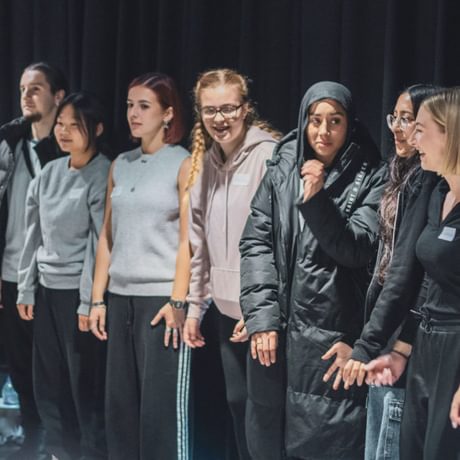 A group of young people line up in a room