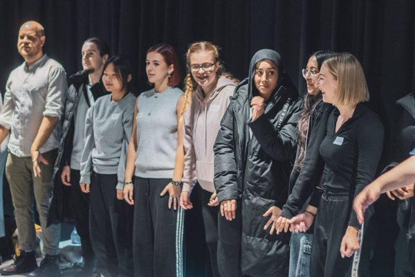 A group of young people line up in a room