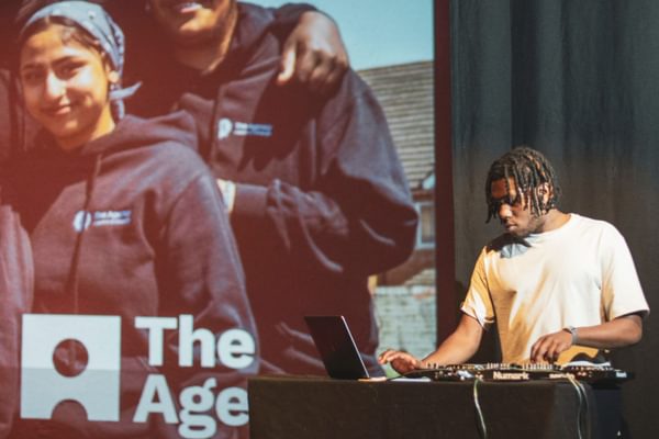 A DJ plays music on a stage